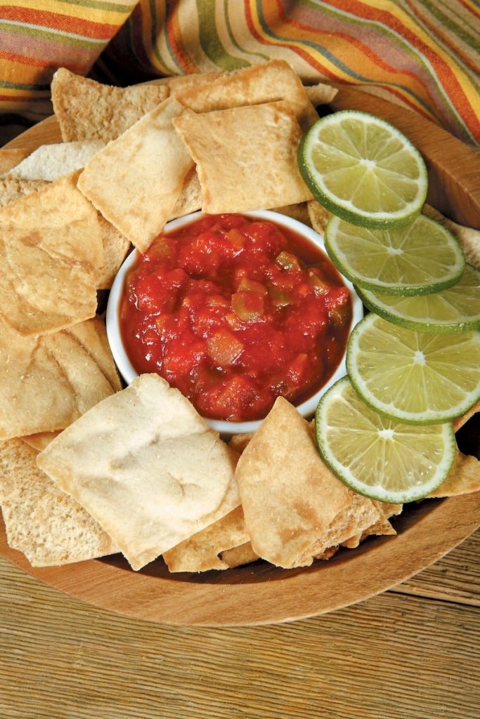 Pita Chips with Salsa and Lime Wheels in Wooden Bowl Food Picture