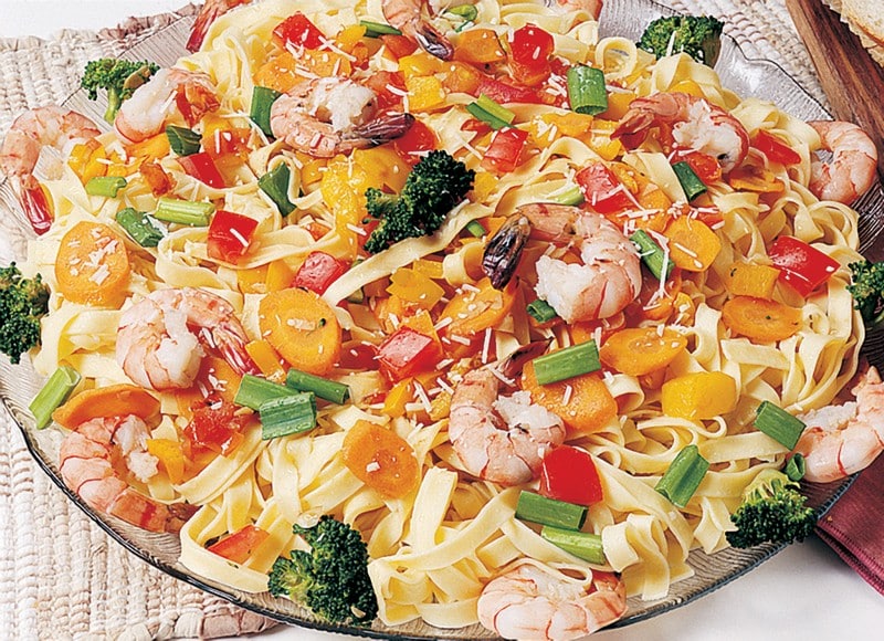 Shrimp over Pasta with Veggies in Clear Bowl Food Picture