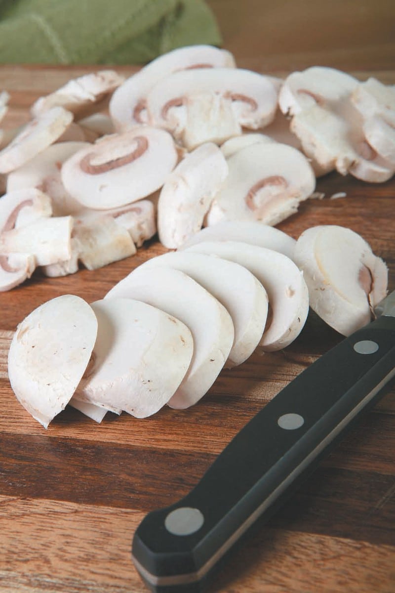 Sliced Mushrooms on Wooden Surface with a Knife Food Picture