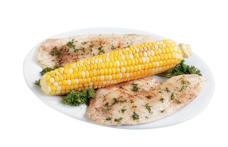 Tilapia with garnish and ear of corn on white plate with white background Food Picture
