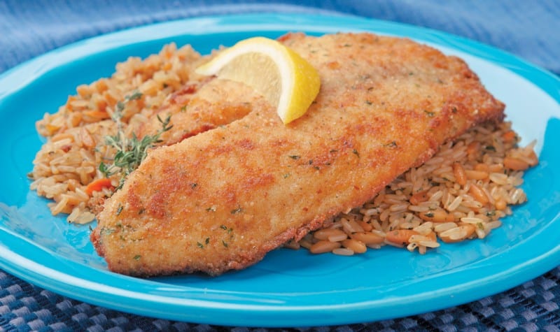 Tilapia over rice with garnish on blue plate Food Picture