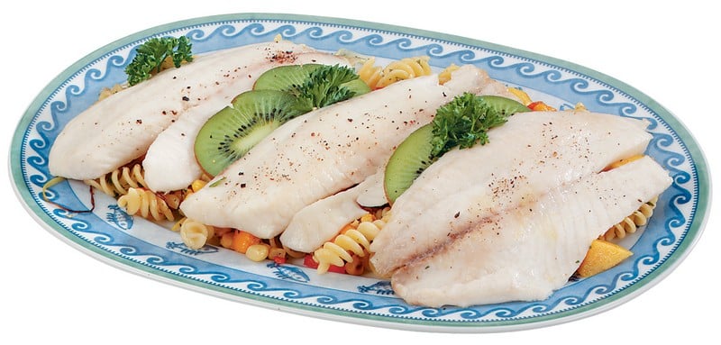 Tilapia over pasta with garnish on a white and blue plate Food Picture