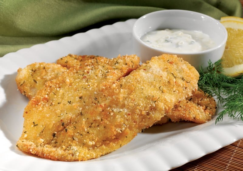 Breaded tilapia with sauce and garnish on white plate Food Picture