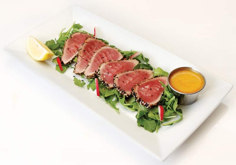 Bluefin tuna over bed of lettuce on white plate Food Picture