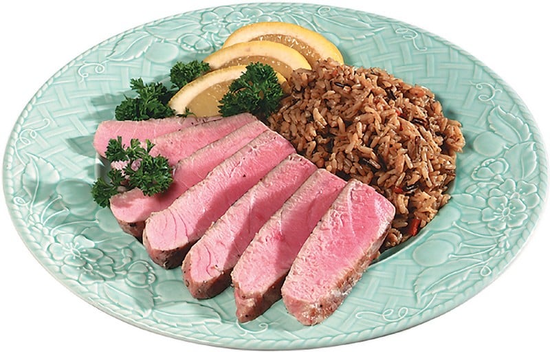 Tuna steak with rice and garnish on light colored plate Food Picture