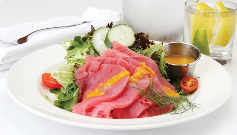 Yellowfin tuna with salad and dressing on white plate with napkin and lemon water Food Picture