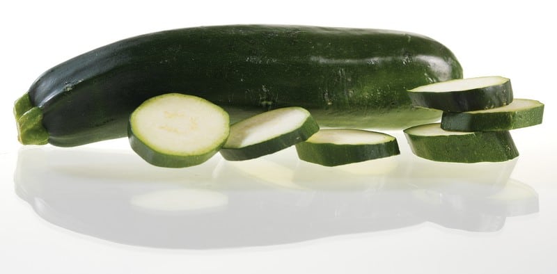 Whole and Sliced Zucchini on White Surface Food Picture